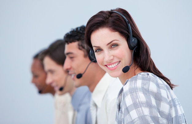 Atraente mulher de negócios e sua equipe trabalhando em um call center