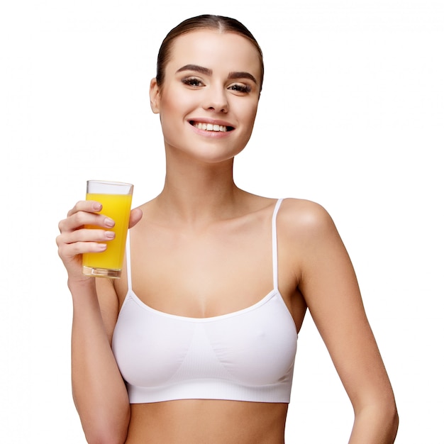 atraente mulher sorridente segurando o copo de suco de laranja em branco