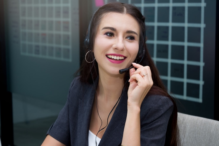 Atraente sorridente mulher caucasiana call center com microfone headset oferecendo ao cliente