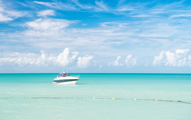 Atraente vista brilhante da exótica colorida bela praia marinha de Antigua St. Johns com barco na água azul e céu com pequenas nuvens em tempo ensolarado ao ar livre em fundo natural, foto horizontal