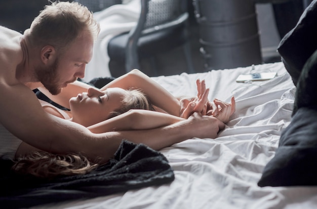 Foto atraentes jovens amantes têm casais brincando juntos na cama, vestindo lingerie sexy em um quarto de hotel.