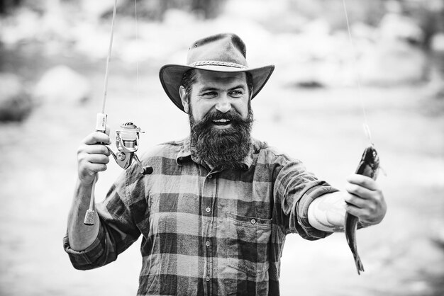 Atrapar un pez grande con una caña de pescar pez en el anzuelo pesca con mosca sosteniendo ingenio de pesca de trucha marrón