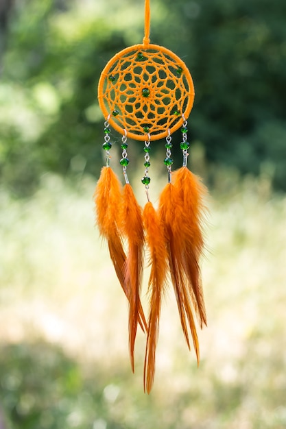 Atrapasueños hechos a mano con hilos de plumas y cuentas colgando de la cuerda.