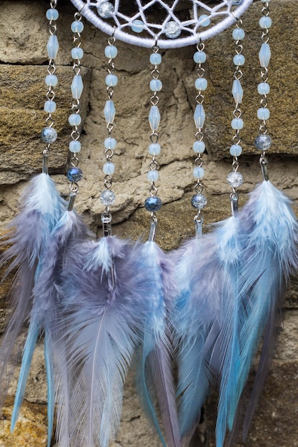 Atrapasueños hechos a mano con hilos de plumas y cuentas colgando de la cuerda.