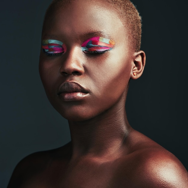 Atrévete a ser diferente Captura recortada de una hermosa mujer con sombra de ojos colorida mientras posa sobre un fondo gris