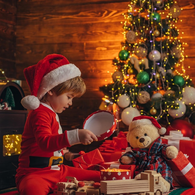 Atributos navideños. Vacaciones familiares. Recuerdos de la infancia. Niño de Santa celebrar la Navidad en casa. Niño niño juega adornos navideños. Feliz y brillante navidad. Actividad y juego infantil