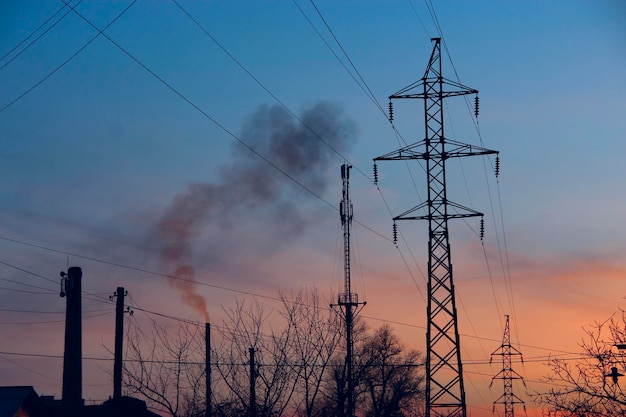 Atributos de la urbanización y la contaminación ambiental Líneas eléctricas y tuberías de fábrica con humo contaminando el aire Consecuencias de la actividad humana