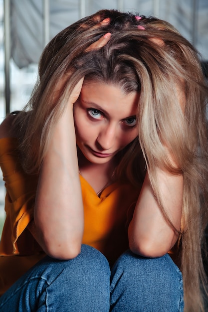 Foto atriz de mulher adulta retrato posando na escadaria em casa vestida de estilo de roupas na sala de estar vintage. mulher com cabelo comprido em estilo jaqueta laranja. conceito de moda retrô e tendência desatualizada