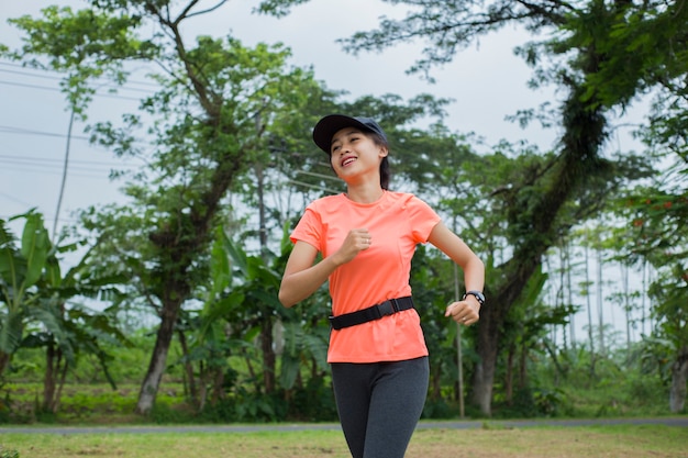 attraktive asiatische Frau, die im Park joggt