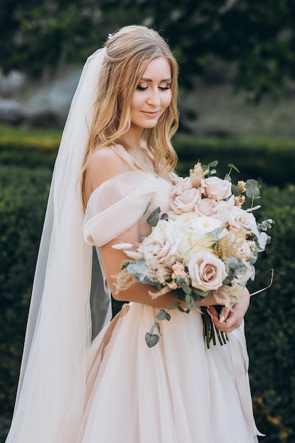 attraktive braut in traditioneller kleidung mit hochzeitsblumenstrauß