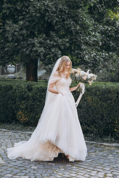 attraktive braut in traditioneller kleidung mit hochzeitsblumenstrauß