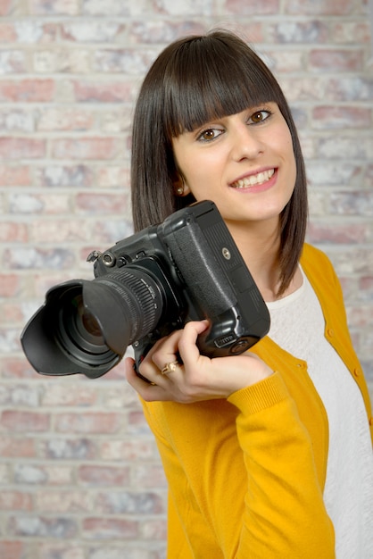 Attraktive Brunettefrau mit Fotokamera