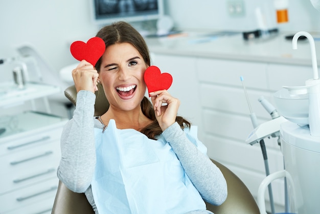 attraktive erwachsene Frau in Zahnarztpraxis mit Herzen with