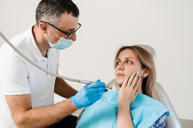 Attraktive Frau Angst vor Zahnarzt Zahnarzt konsultiert verängstigtes Mädchen in der Zahnheilkunde Behandlung von Zähnen und Zahnschmerzen in der Zahnheilkunde