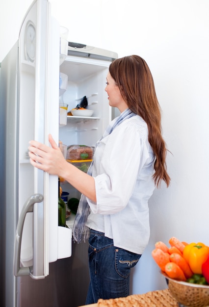 Attraktive Frau, die nach etwas im Kühlschrank sucht
