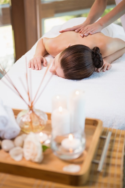 Attraktive Frau, die Rückenmassage in der Badekurortmitte empfängt