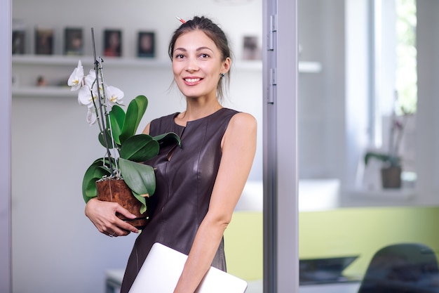 Attraktive Frau im Lederkleid, die in neues Büro zieht