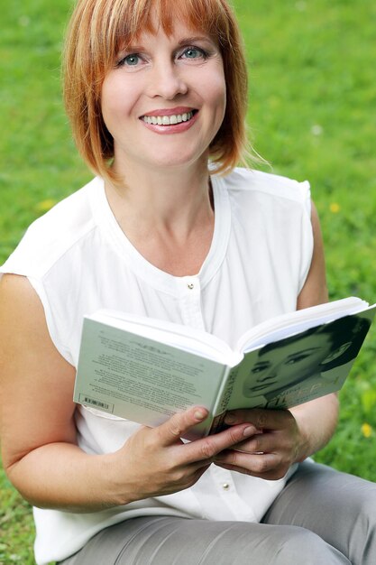 Foto attraktive frau im park, die ein buch liest