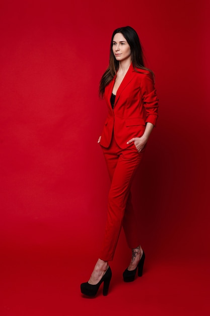 Attraktive Frau im roten Anzug und schwarzen Absätzen