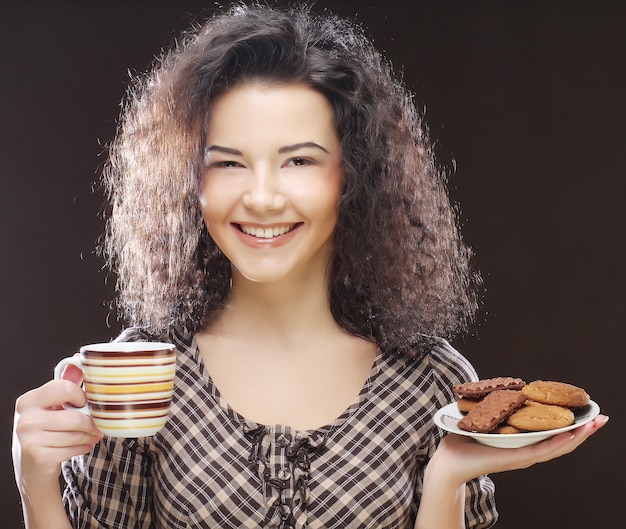 Attraktive Frau mit Kaffee und Keksen