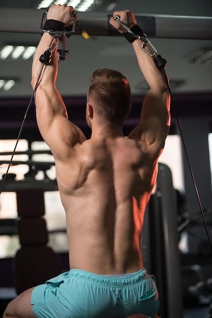 Attraktive Frau ruht sich nach dem Training im Fitnesscenter auf der Bank aus