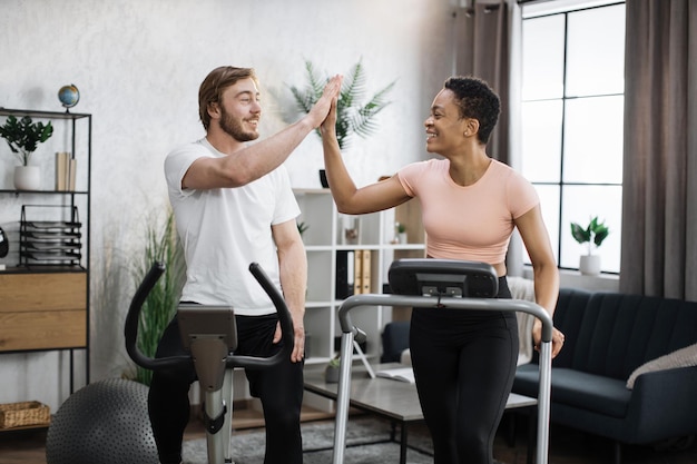 Attraktive Frauen und Männer trainieren zu Hause an Fitness