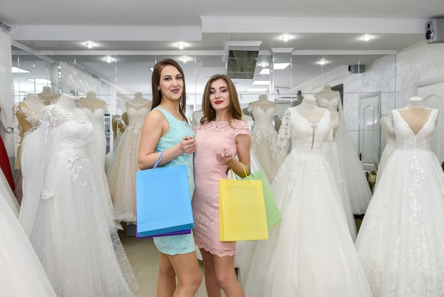 Attraktive Freunde mit Einkaufstüten im Hochzeitssalon