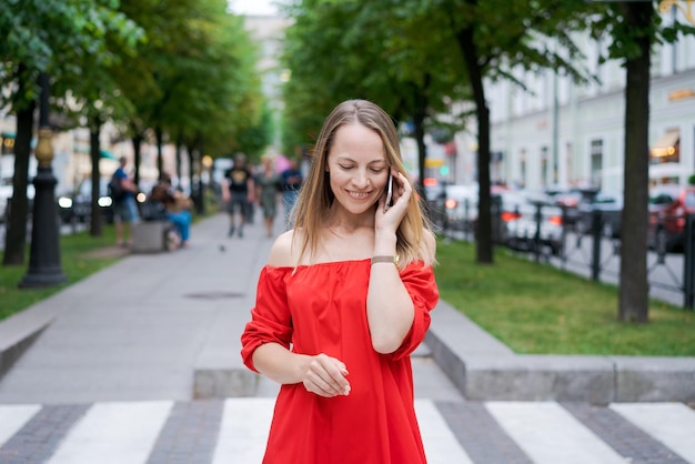 Attraktive Geschäftsfrau, die an einem Mobiltelefon mit einem stehenden Kunden spricht