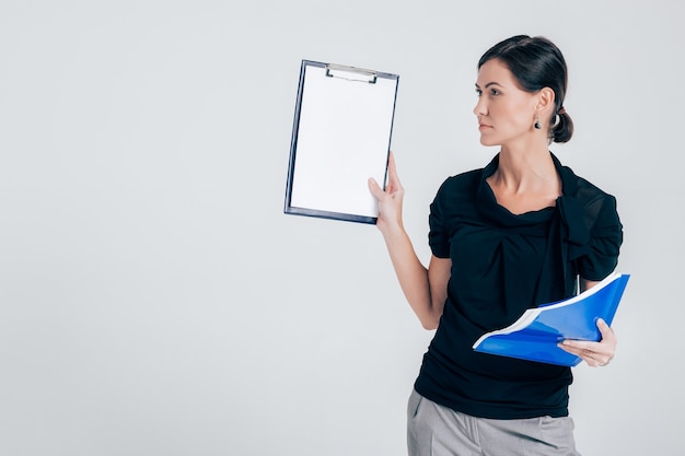 Attraktive Geschäftsfrau, die einen Ordner mit Dokumenten auf einem grauen Hintergrund hält