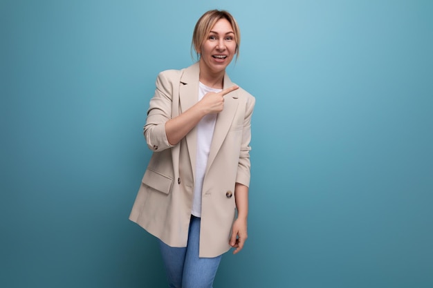 Attraktive Geschäftsfrau in einer beigen Jacke zeigt, dass sie eine Idee mit dem Finger auf einem Studio hat