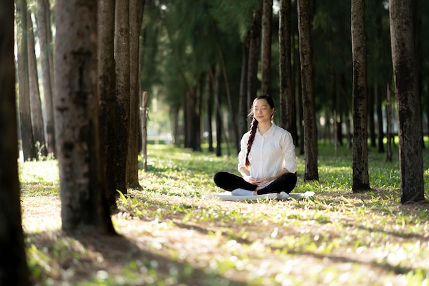 Foto attraktive gesunde asiatische frau, die im park meditiert