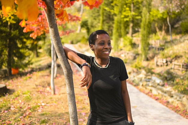 Attraktive glücklich lächelnde junge natürliche Schönheit kurzhaarige afrikanische Frau, die total schwarzes Gehen trägt