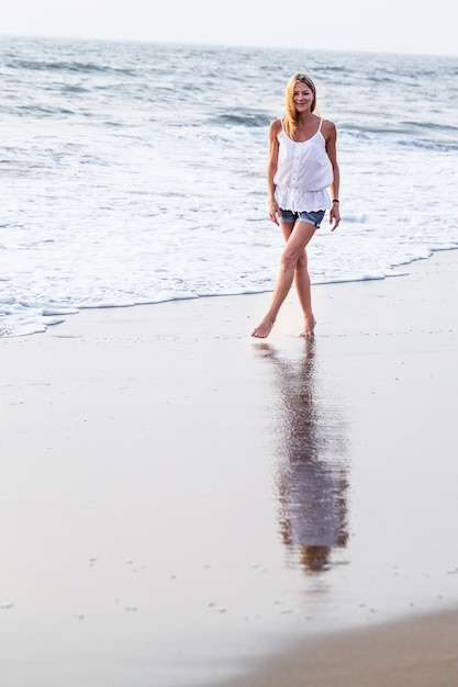 Attraktive glückliche fällige touristische Frau auf tropischem Strand des asiatischen Sandes.