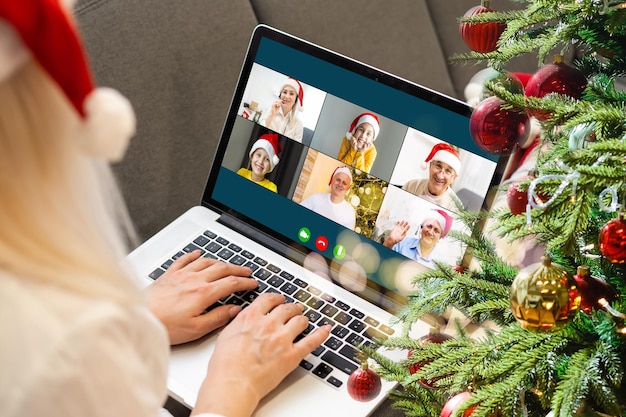 Attraktive, glückliche junge Studentin beim Videochat, winken. Weihnachten