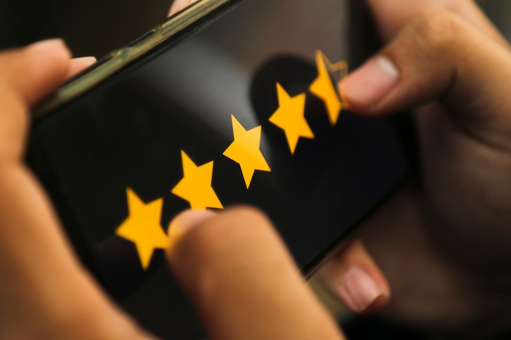 Foto attraktive hände, die vier-punkte-fünf-sterne-bewertung auf einem smartphone geben