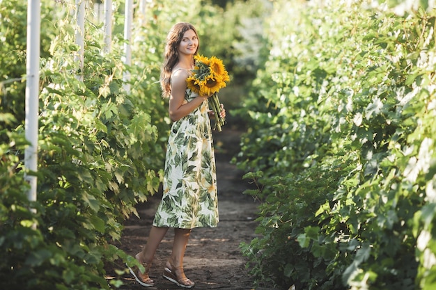 Attraktive junge Dame mit Sonnenblume. Schöne Frau draußen im Sommer.