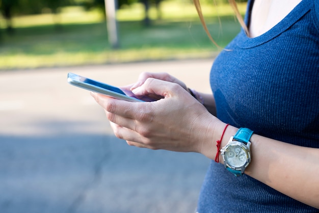 Attraktive junge Frau, die auf der Straße texting ist