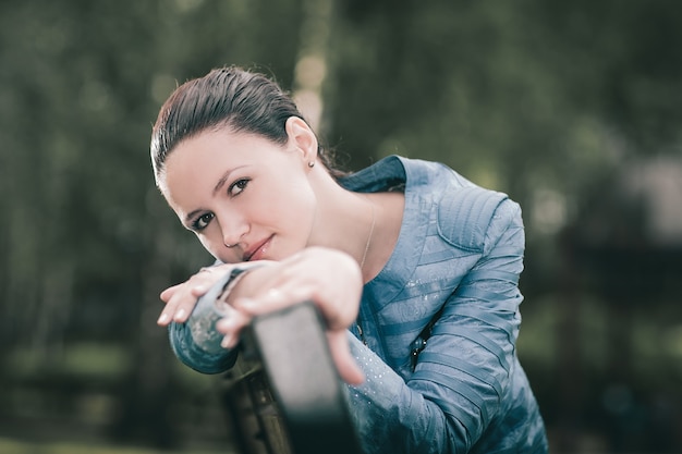 Attraktive junge Frau, die auf einer Parkbank sitzt