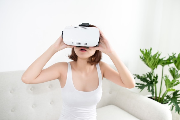 Attraktive junge Frau, die ihr VR-Headset einstellt und lächelt