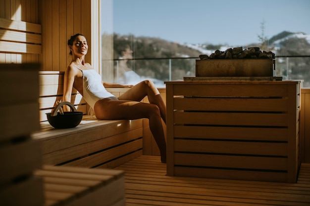 Attraktive junge Frau, die sich in der Sauna entspannt