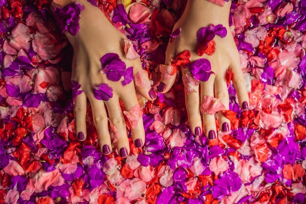 Attraktive junge Frau im Bad mit Blütenblättern von tropischen Blumen und Aromaölen Spa-Behandlungen zur Hautverjüngung Verführerische Frau im Spa-Salon Mädchen entspannt in der Badewanne mit Blütenblättern Luxus