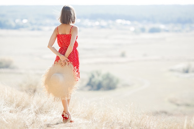 Attraktive junge Frau im Freien. Dame, die rotes Kleid und roten Lippenstift trägt. Schließen Sie herauf Porträt des schönen weiblichen Modells.