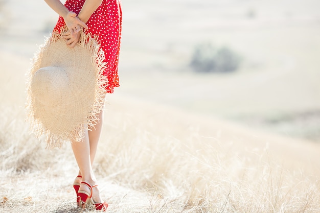 Attraktive junge Frau im Freien. Dame, die rotes Kleid und roten Lippenstift trägt. Schließen Sie herauf Porträt des schönen weiblichen Modells.