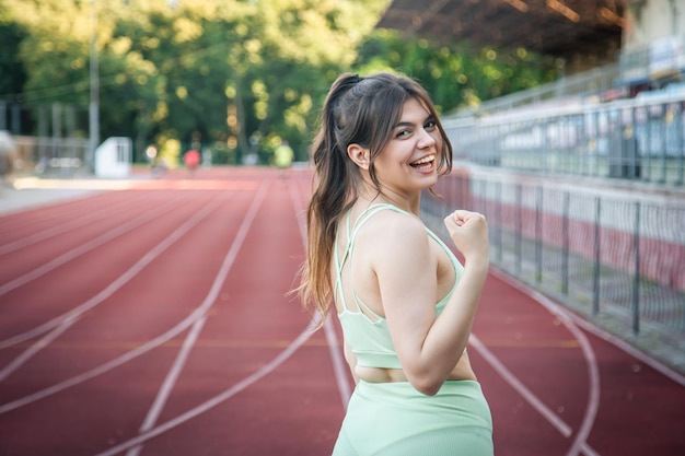 Attraktive junge Frau in Sportkleidung beim Joggen im Stadion