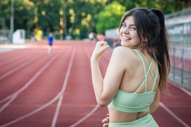 Attraktive junge Frau in Sportkleidung beim Joggen im Stadion