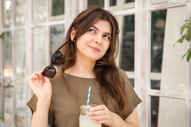 Attraktive junge Frau mit einem Glas Limonade an einem heißen Sommertag