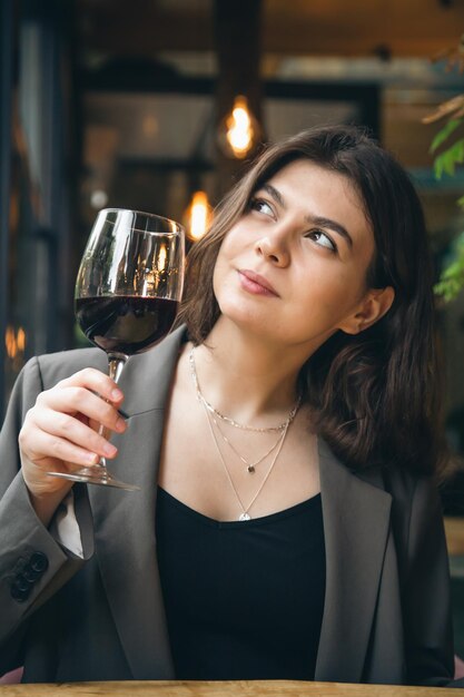 Attraktive junge Frau mit einem Glas Wein in einem Restaurant