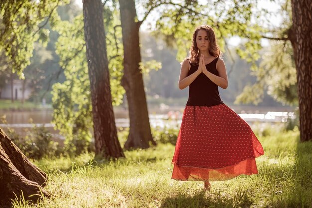 Attraktive junge Frau praktiziert morgens Yoga und macht Asana Vrikshasana