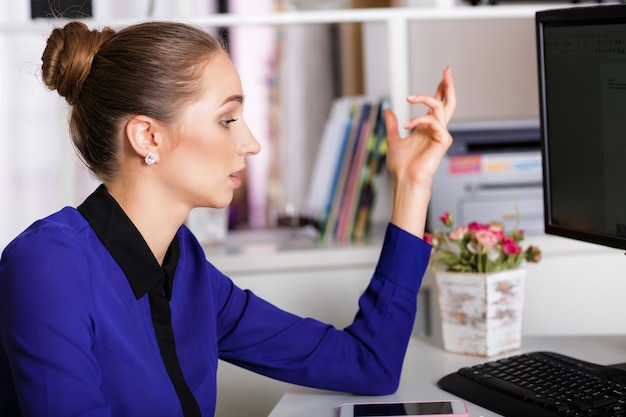 Attraktive junge Geschäftsfrau, die im Büro arbeitet