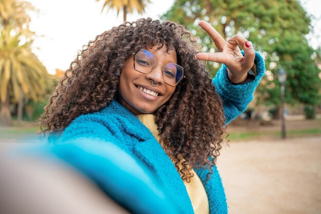 Attraktive lateinamerikanische Frau lächelt, macht ein Selfie, positiv, fröhlich, trendy Mädchen posiert